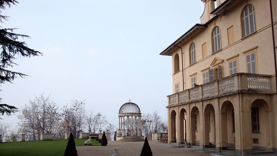 Facciata porticata della villa ottocentesca affacciata sul giardino con belvedere.